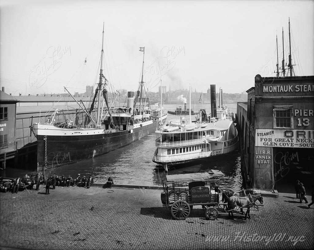 A photograph of the piers at Wall Street with two large boats docked and a Colgate carriage with horses parked on the promenade.