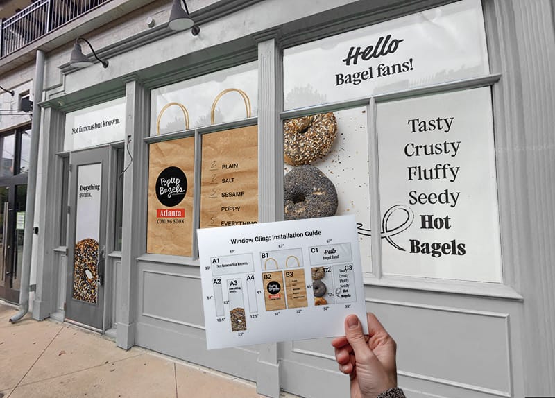 photo of a storefront with branded window clings, in the foreground a hand holds up a schmetic that corresponds to the graphics